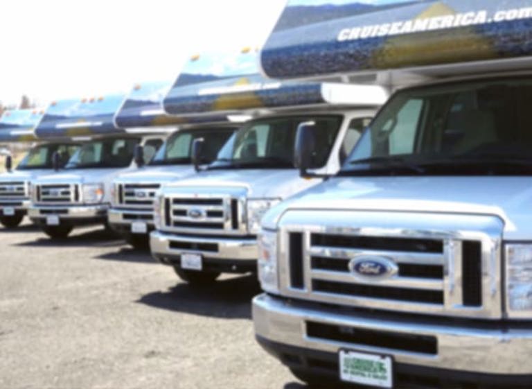 Front view of a row of RVs in a parking lot.